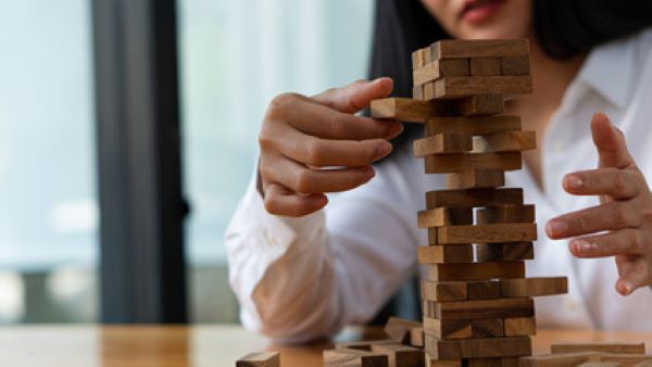Seguros educativos; imagen de una mujer arreglando unas piezas de un juego como símbolo del seguro educativo de sus hijos.