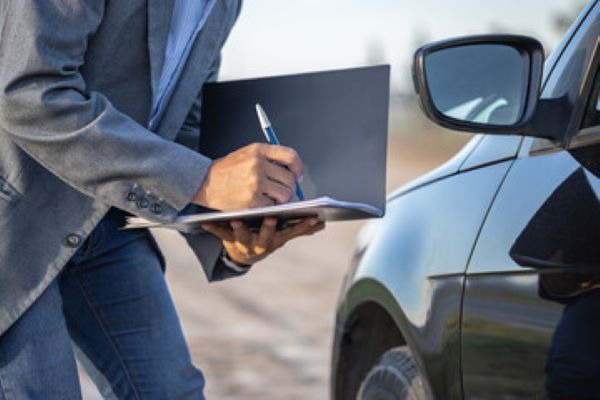 Seguro de auto; imagen de unas personas revisando algunos documentos del seguro para cubrir daños a su auto.