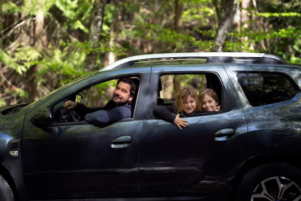 Seguro obligatorio de autos en México; familia sonriendo dentro de un auto.