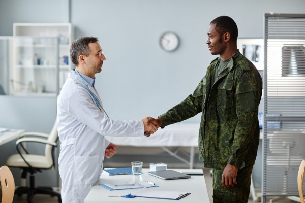 Qué es un seguro de gastos médicos mayores; Doctor estrechando la mano con un hombre