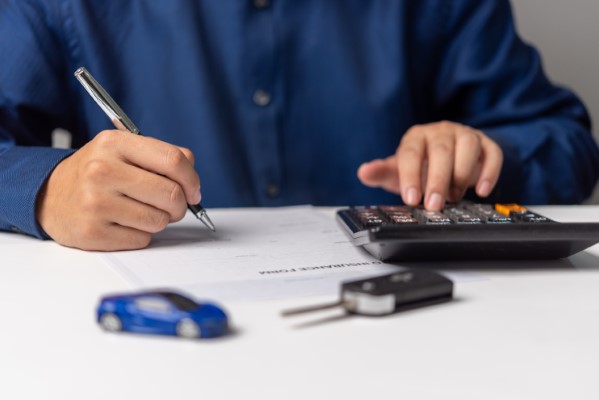 Por qué contratar un seguro de auto; imagen de un hombre realizando una serie de datos para una póliza.